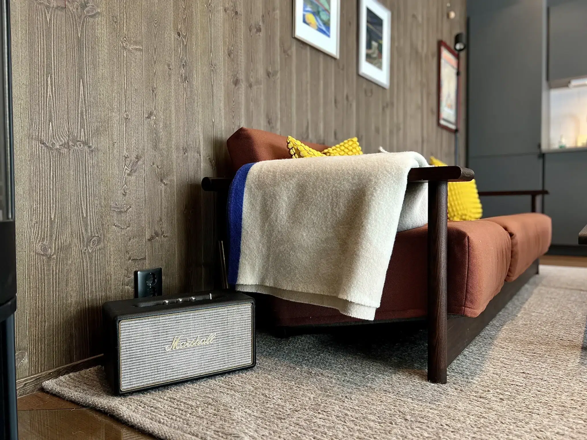 Detaljbild i vardagsrum Fjällbäcken 5C med Marshall-högtalare, soffa och färgglad stilren inredning – premiumboende i Sälen